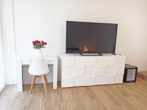 una sala de estar con TV en una cómoda blanca en Guest House - La bella vita en Orosei