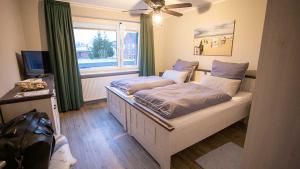 Schlafzimmer mit einem Bett und einem Fenster in der Unterkunft 168 Salzwiese Ferienwohnung in Accumersiel