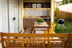 a patio with a table and chairs and a counter at Village Duplex Confortável e Acolhedor junto a Natureza in Itacimirim
