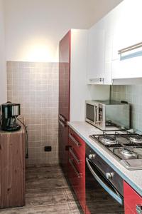 a kitchen with red cabinets and a stove top oven at Casa Simone in Malcesine