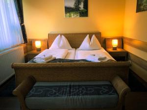 ein Schlafzimmer mit einem Bett mit zwei Lampen und einem Stuhl in der Unterkunft Hotel Mallnitz in Mallnitz