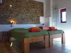 a bedroom with a bed with a green blanket on it at Casa Vermelha & Casa Azul in Castelo de Vide