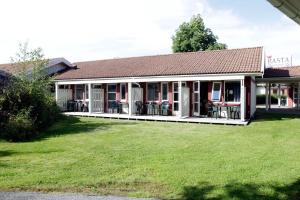 a building with tables and chairs in a yard at Nordby Hotell in Lervik