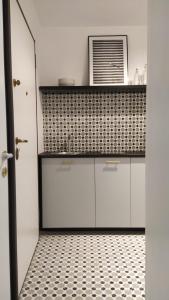 a kitchen with white cabinets and a tile floor at Botteghelle14 suites in Salerno