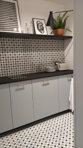 a kitchen with white cabinets and a black counter top at Botteghelle14 suites in Salerno