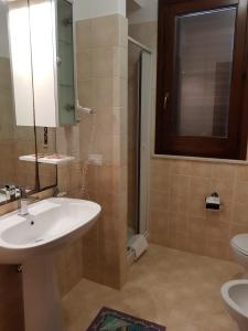 bagno con lavandino e specchio di La Pineta San Vito Apartment a San Vito lo Capo