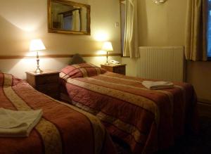 A bed or beds in a room at Riverside Hotel 