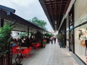 a sidewalk with red chairs and tables and people walking down it at Downtown apartment in walk zone with 3 bedrooms and garage in Novi Sad