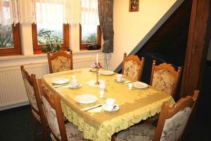 a dining room table with a yellow table cloth at Ferienwohnungen Christel in Wernigerode