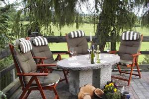 eine Terrasse mit Stühlen und einem Tisch mit Weingläsern in der Unterkunft Ferienwohnungen Christel in Wernigerode