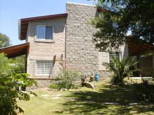 een stenen huis met een tuin ervoor bij Villa Carlos Paz Alojamiento Santa Ponsa in Villa Carlos Paz