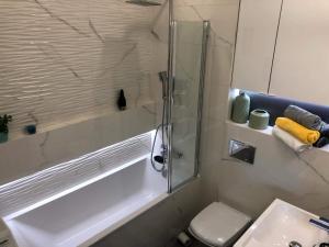łazienka z wanną, toaletą i umywalką w obiekcie Apartamenty Garden w mieście Słupsk