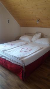 Schlafzimmer mit einem Bett mit weißer Bettwäsche und Kissen in der Unterkunft Vakáció Apartman in Balatonalmádi