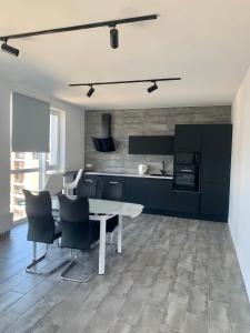 a kitchen with a white table and black cabinets at 4 rooms apartment with a view to the Dnieper River in Kyiv