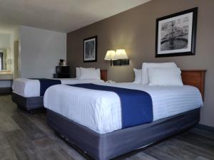 a hotel room with two beds with white and blue sheets at Cedar Cove in Sandusky
