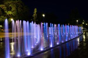 a bunch of water fountains are lit up at night at Belvárosi Apartmanszálló - Kiskunfélegyháza in Kiskunfélegyháza