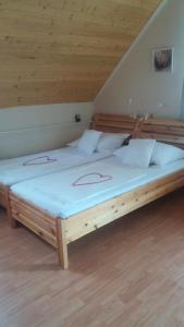 2 Betten in einem Zimmer mit Holzdecke in der Unterkunft Vakáció Apartman in Balatonalmádi