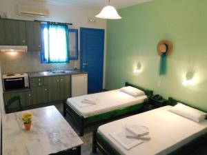 Habitación con 2 camas y cocina. en Studio Elisabeth, en Agios Ioannis