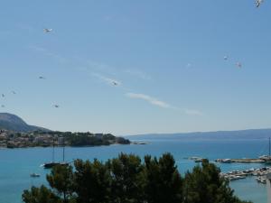 an airplane flying over a body of water with boats at Rooms & Apartments Bruno in Split