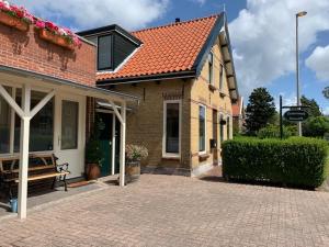 a brick house with a bench in front of it at Oostvoornsch Gastenverblijf in Oostvoorne