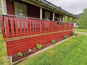 a red fence in front of a house at Holmset Camping and Fishing in Namdalseid