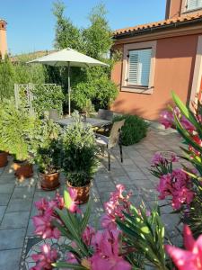 een patio met een tafel, planten en een parasol bij VILLA ANCORA MEDULIN in Medulin