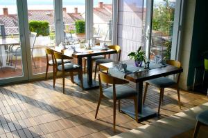 a dining room with tables and chairs and windows at Apartments Villa Azzurra Bol in Bol