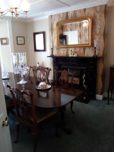 a dining room with a table and a fireplace at Belvedere House in Middleton in Teesdale