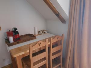 a room with a table and two wooden chairs at Studio dans résidence de tourisme*** in Giez +8 photos