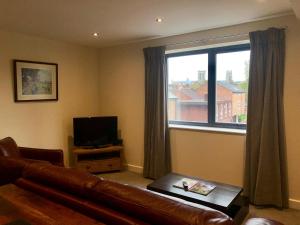 a living room with a couch and a large window at Vikings Two Bedroom Apartment With Free Parking. in York