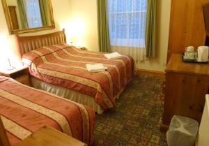 A bed or beds in a room at Riverside Hotel 