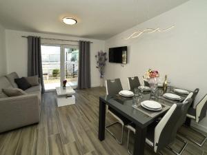 een woonkamer met een eettafel en een bank bij Apartmani Antonia in Trogir