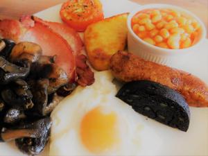 un plato de desayuno con champiñones y tocino en The Old Registry guest house, en Haworth