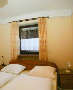 a bedroom with a bed and a window with curtains at Gästehaus Steiger in Bad Birnbach