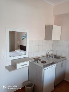 a small kitchen with a sink and a mirror at Teo Rooms in Paralia Katerinis