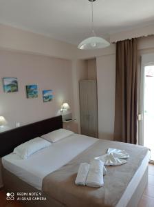 a bedroom with a large bed with two towels on it at Teo Rooms in Paralia Katerinis