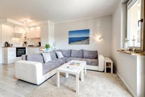 - un salon avec un canapé et une table dans l'établissement White Apartment Swinemünde, à Świnoujście