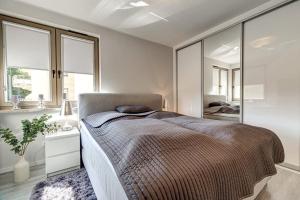 ein Schlafzimmer mit einem großen Bett und einem Spiegel in der Unterkunft White Apartment Swinemünde in Świnoujście
