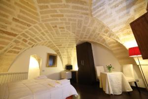 a bedroom with a bed in a room with a stone ceiling at Bed & Breakfast Idomeneo 63 in Lecce