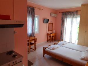 a bedroom with a bed and a room with a window at STUDIOS LEFTERIS in Nydri
