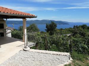 a house with a balcony with a view of the water at Apartments Tinka in Brseč