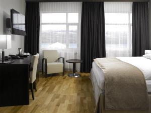 a hotel room with a bed and a desk and window at Hotel Kea by Keahotels in Akureyri