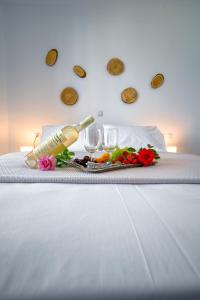 a table with wine glasses and flowers on a bed at Ammos Serifos in Serifos Chora