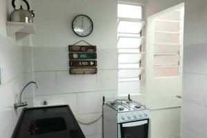 cocina con fogones y reloj en la pared en Amplo, aconchegante e pertinho de tudo, en Porto Alegre 27 fotos más