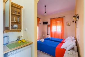 a small room with a bed and a kitchen at Pension Soula in Skopelos Town