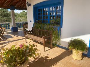 una panca di legno seduta su un patio con piante di Casa Campo Tipo Fazenda a Mairinque