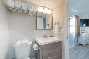 La salle de bains est pourvue de toilettes, d'un lavabo et d'un miroir. dans l'établissement International Dr. - Volcano Bay, Pool and Lake view, à Orlando