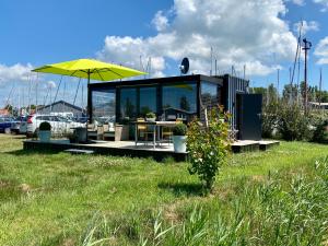 Un pequeño edificio con una mesa y una sombrilla. en Rent to ENJOY, en Warns