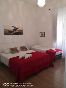 sypialnia z 2 łóżkami z czerwoną pościelą w obiekcie Trastevere four seasons Glorioso w Rzymie