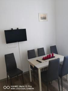 pokój ze stołem, krzesłami i telewizorem w obiekcie Trastevere four seasons Glorioso w Rzymie +37 zdjęć
